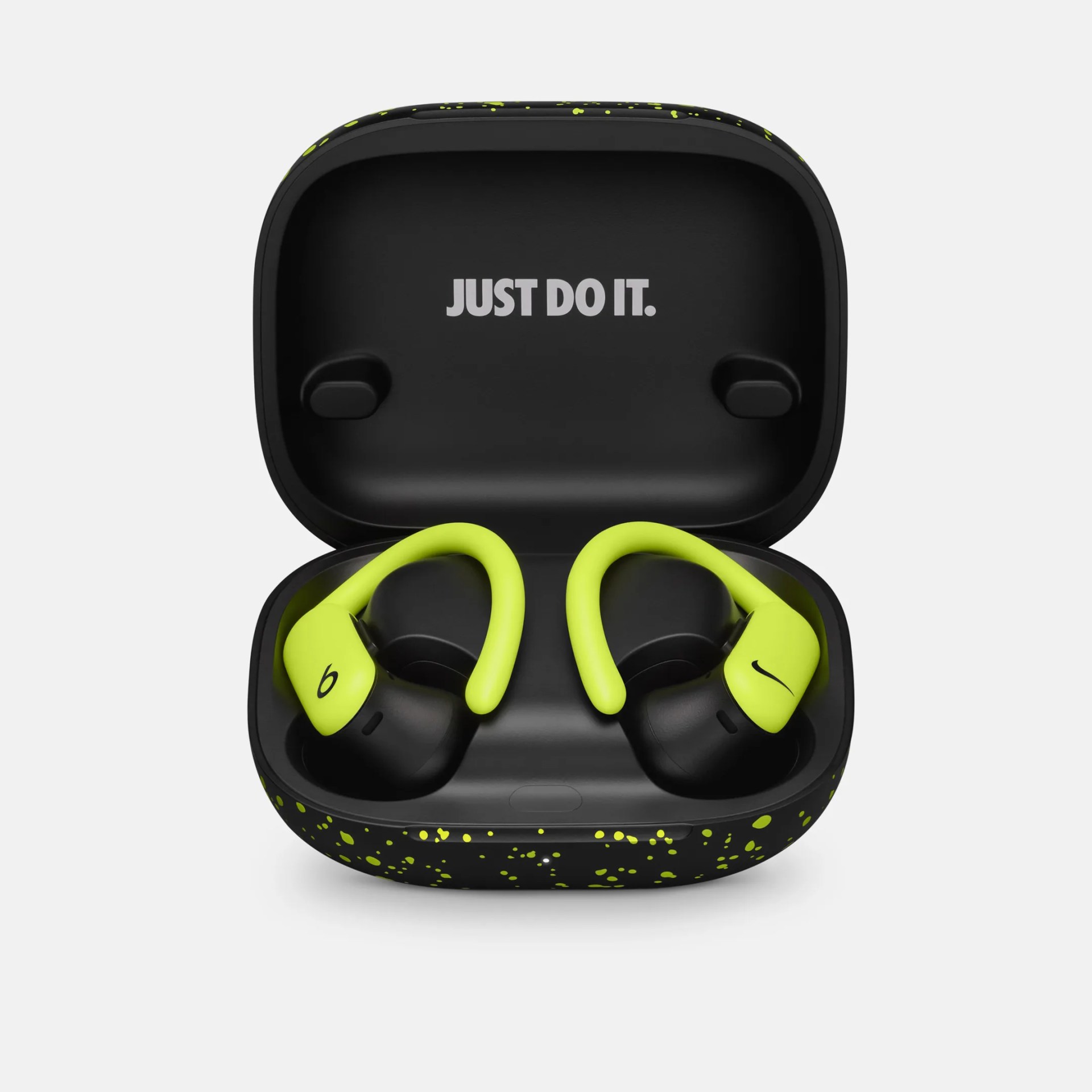 Black and neon yellow wireless earbuds with ear hooks in a black charging case with yellow speckles and "JUST DO IT." text inside the lid.
