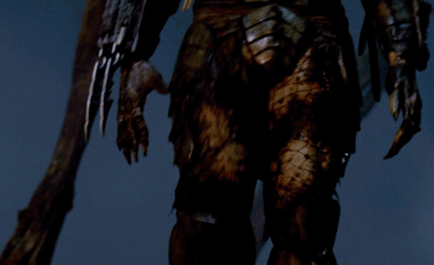 Close-up of a creature with scaly, armored legs and clawed hands against a dark background.