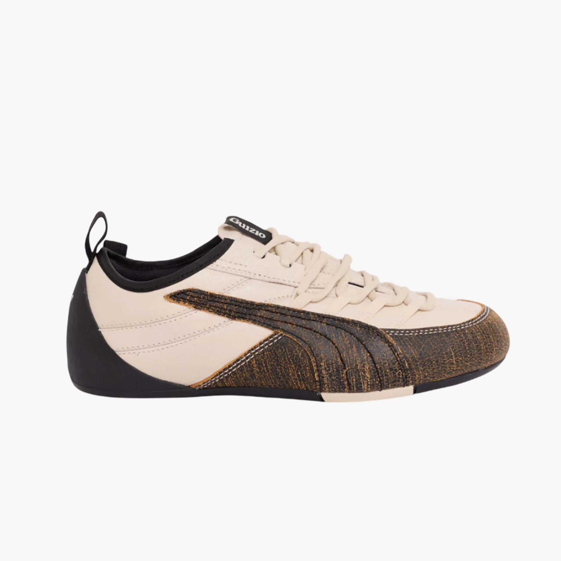 Beige and black low-top sneaker with textured black and brown detailing and laces.
