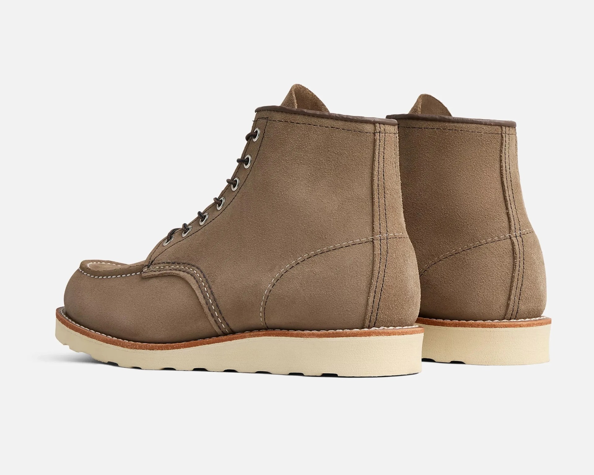 Pair of tan suede lace-up boots with white rubber soles shown from the back and side.