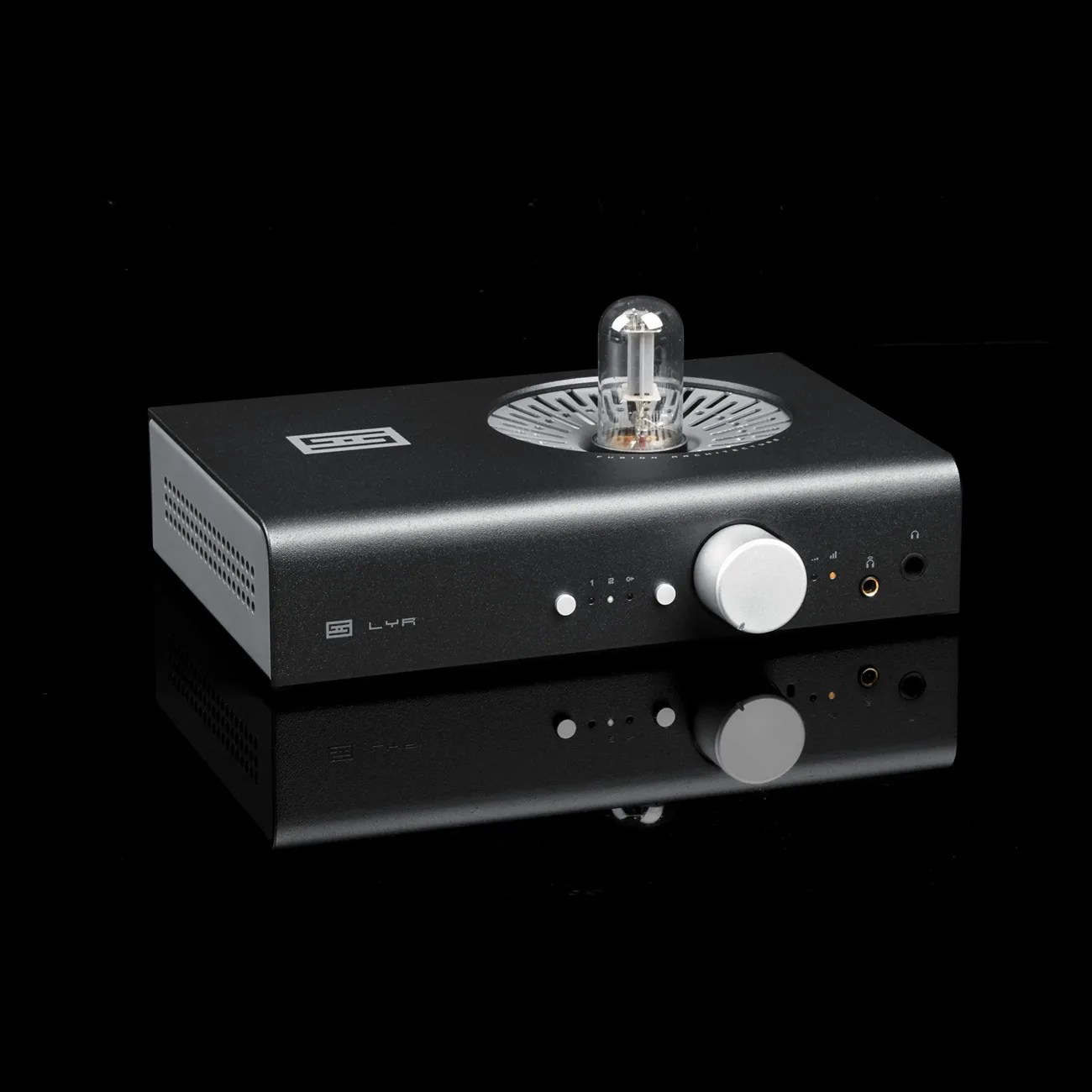 Black Schiit Lyr headphone amplifier with silver volume knob and visible vacuum tube on top, reflected on glossy black surface.