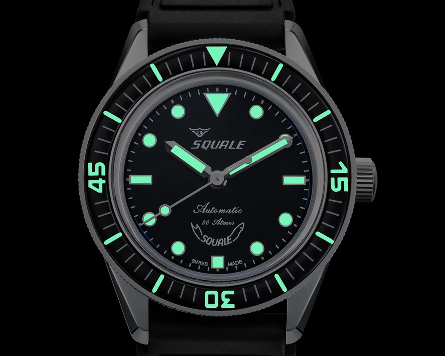 Black Squale dive watch with luminous green markers and hands on a black rubber strap.