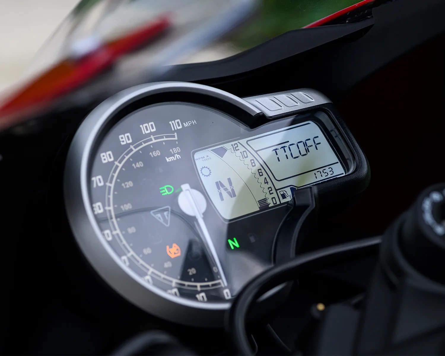 Close-up of a motorcycle speedometer and digital display showing 0 mph, neutral gear, and "TTC OFF" message.