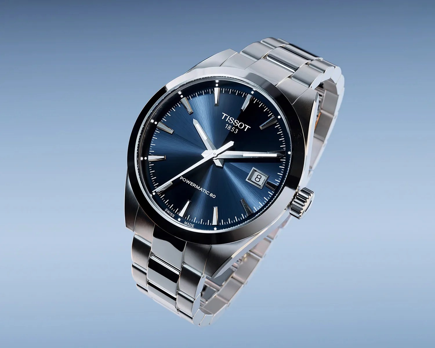 Silver stainless steel Tissot wristwatch with blue sunburst dial and date window at 3 o'clock.