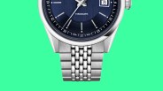 Close-up of a silver metal watch band attached to a blue dial watch with "VISODATE" text.