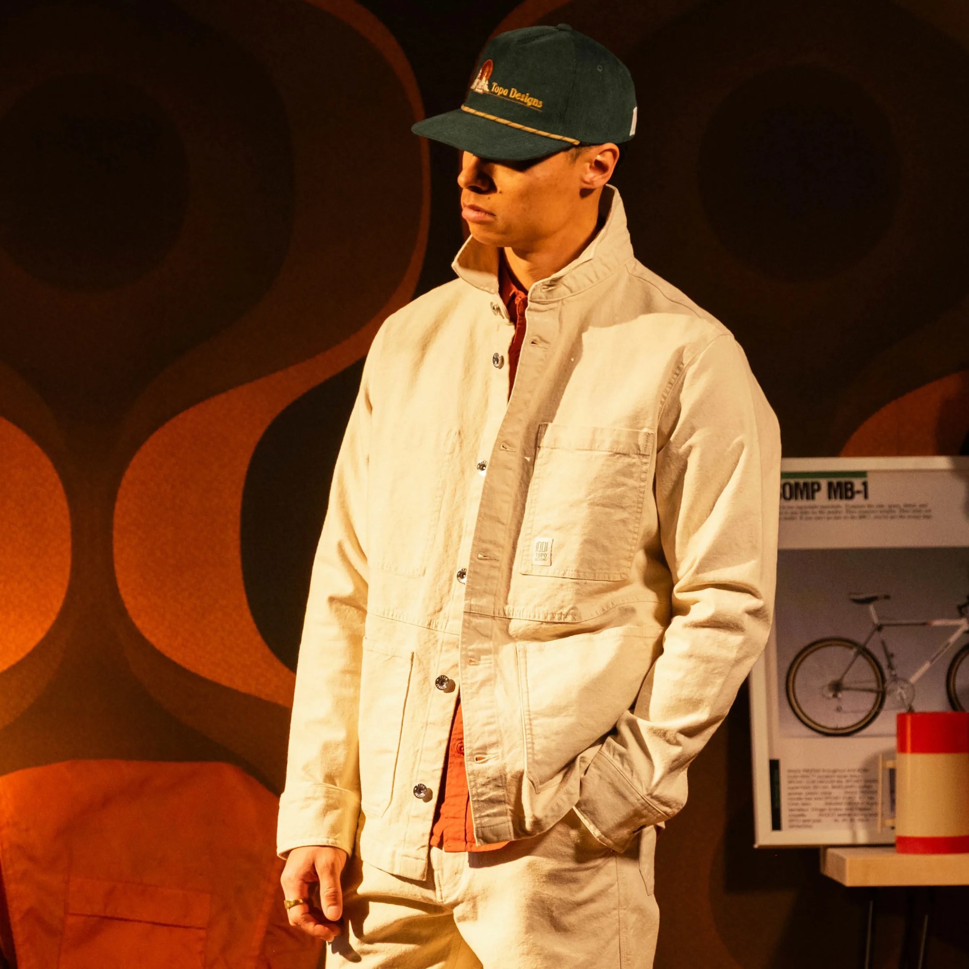 A man wearing a white chore coat and a blue hat.