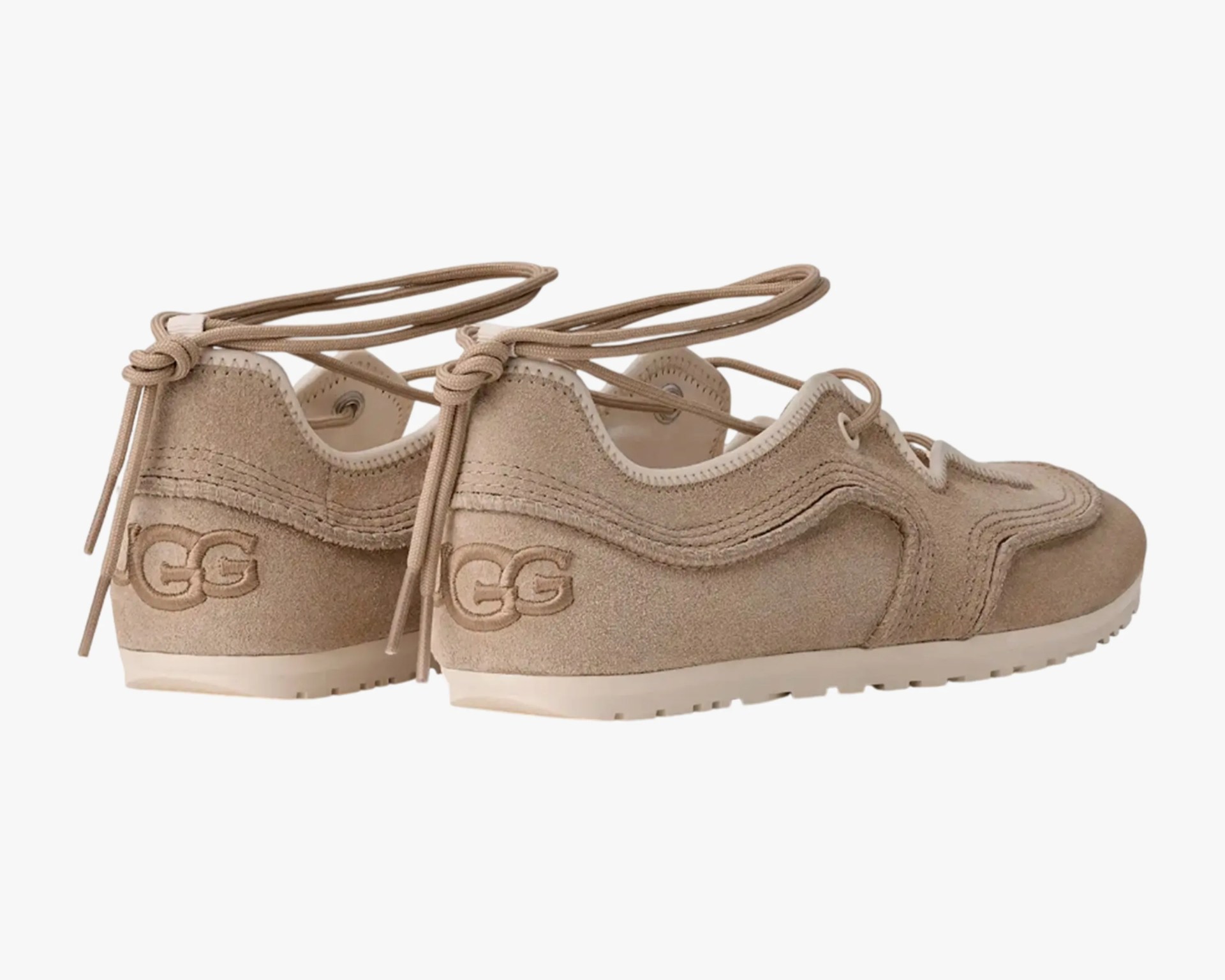 Pair of beige suede UGG sneakers with lace-up design and white rubber soles.
