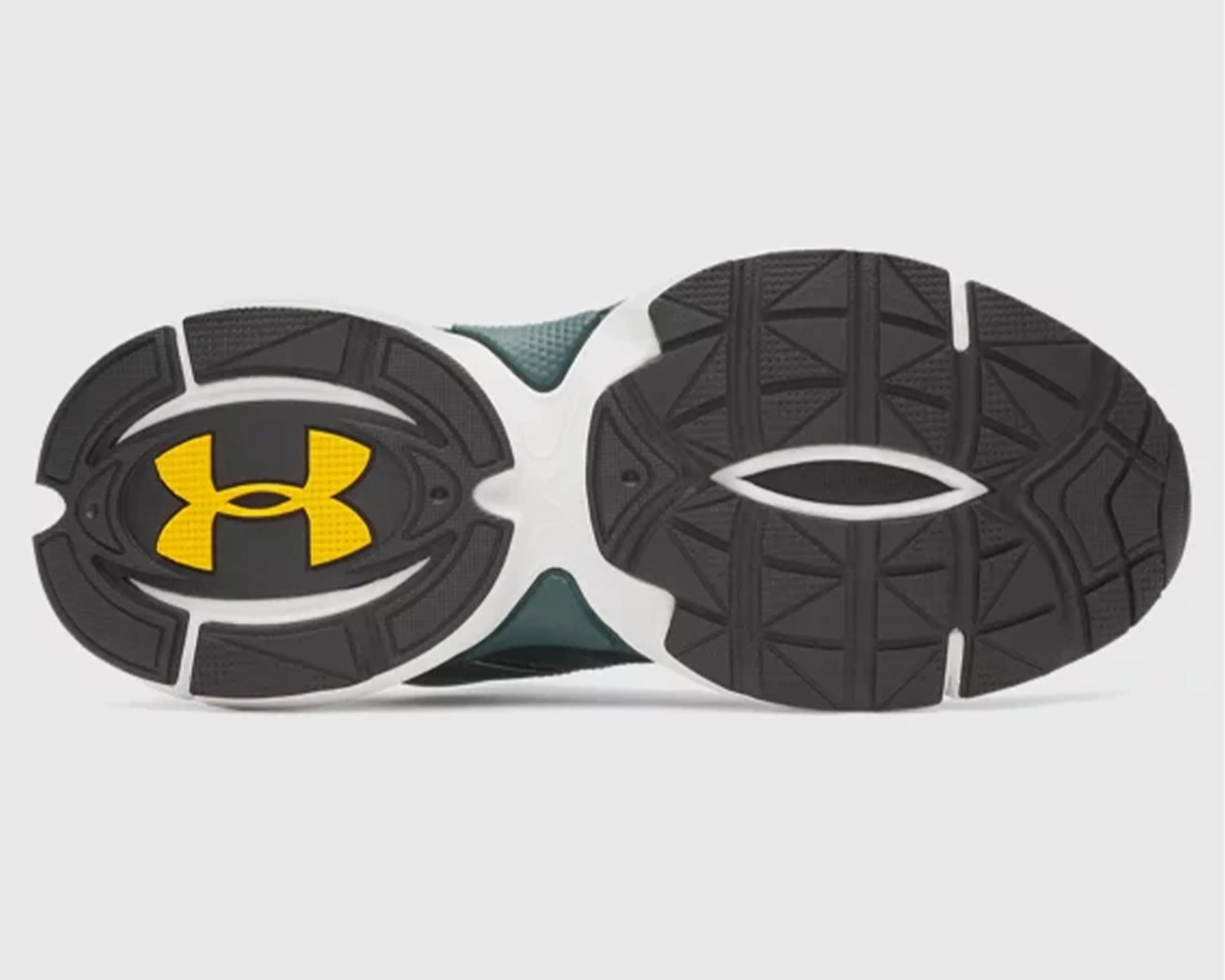 Black and white shoe sole with yellow Under Armour logo and textured grip pattern.