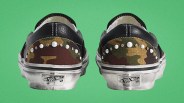 Pair of camo-patterned Vans sneakers with black leather accents and pearl-like studs on the heel.