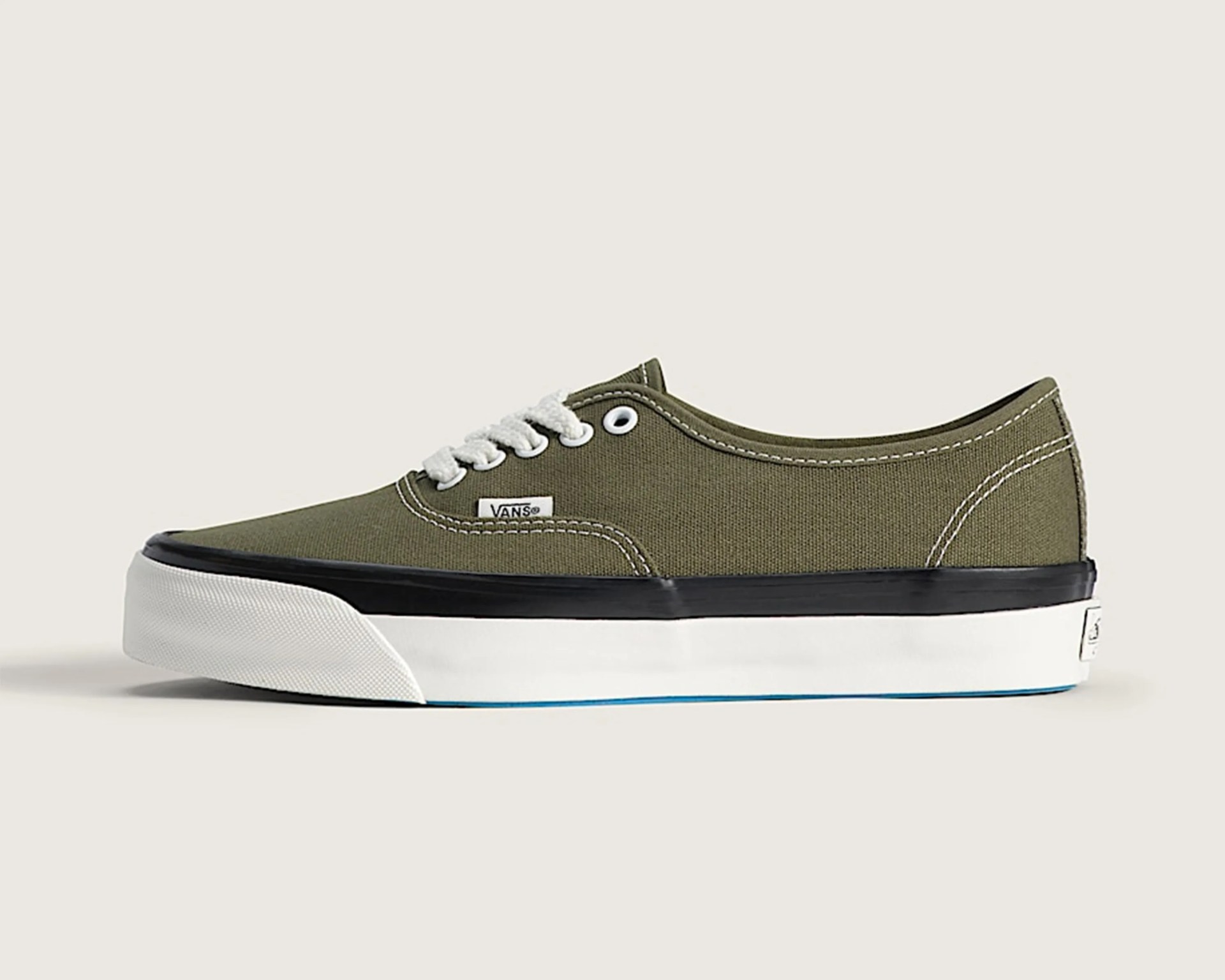 Olive green Vans low-top canvas sneaker with white laces and black-trimmed white sole.