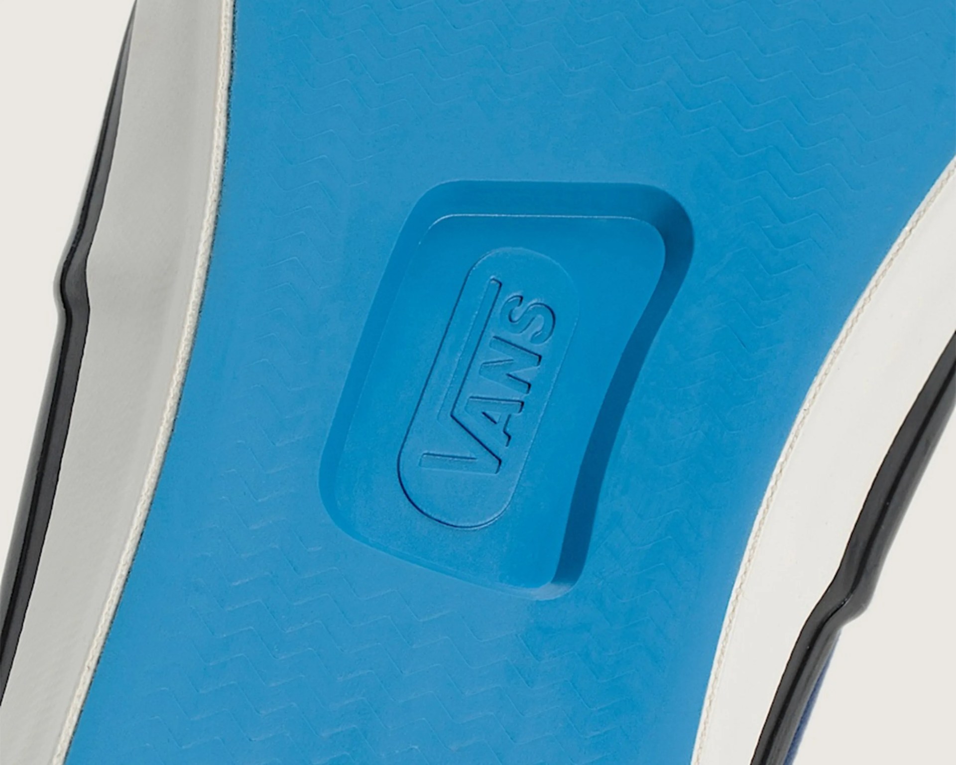 Close-up of a blue Vans shoe sole with the Vans logo embossed in the center.