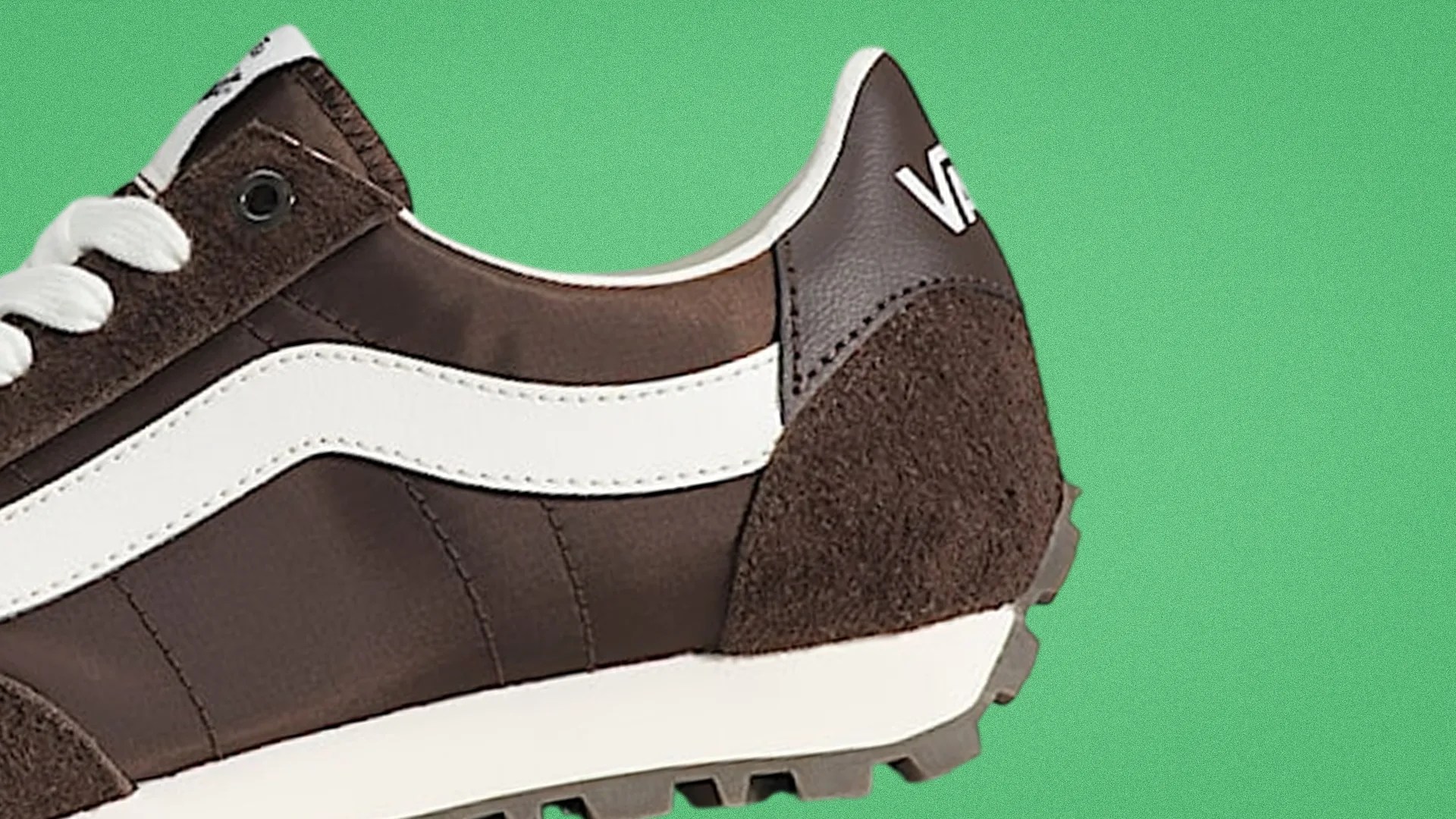 Brown and white Vans sneaker with suede and leather details on a green background.