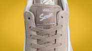 Close-up of beige Vans Serio sneaker tongue with beige laces against a yellow background.