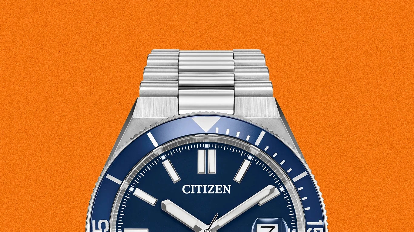 Silver Citizen wristwatch with a blue dial and bezel, white hour markers, and date window on an orange background.