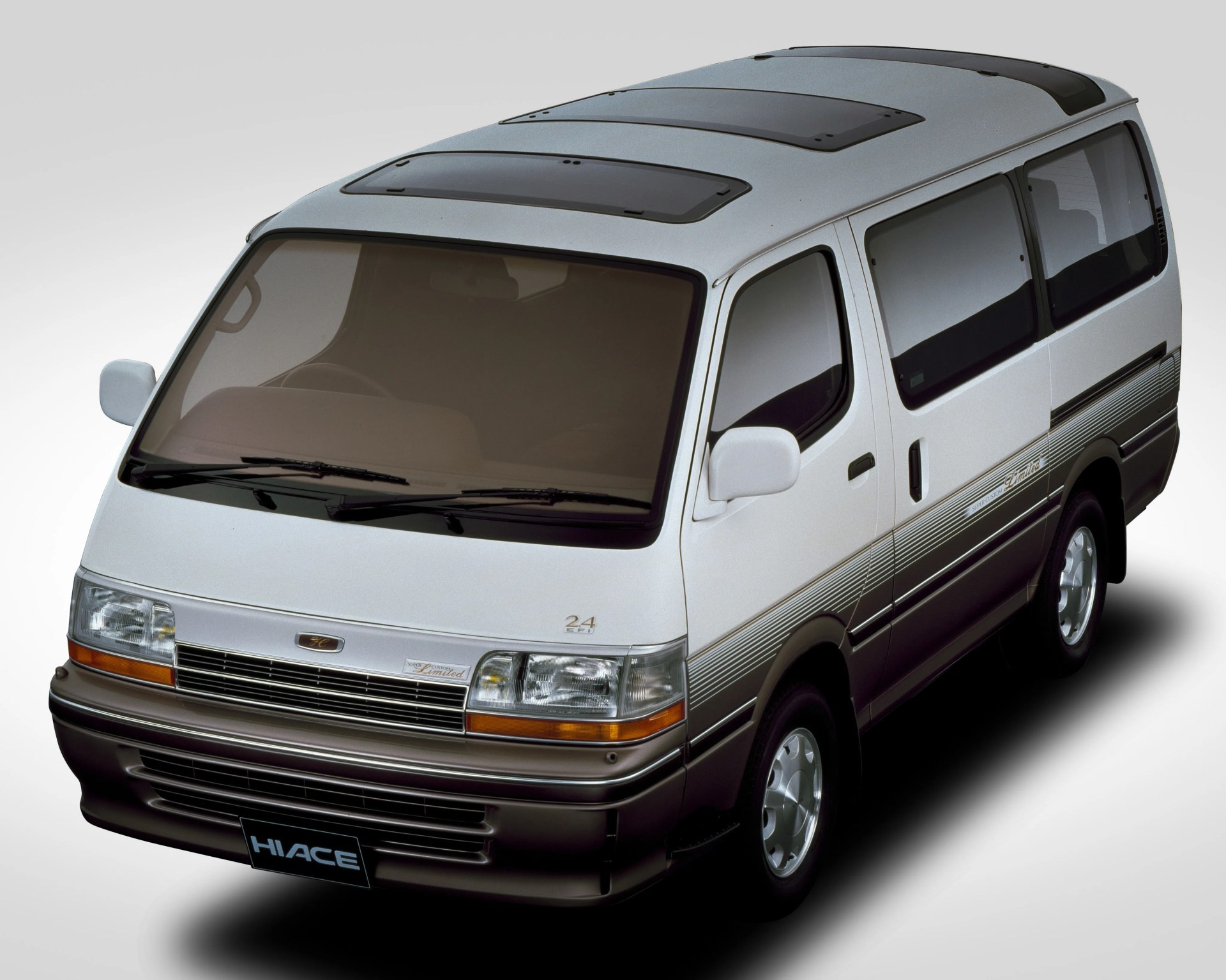 Silver and brown Toyota Hiace van with tinted windows and dual sunroofs on the roof.