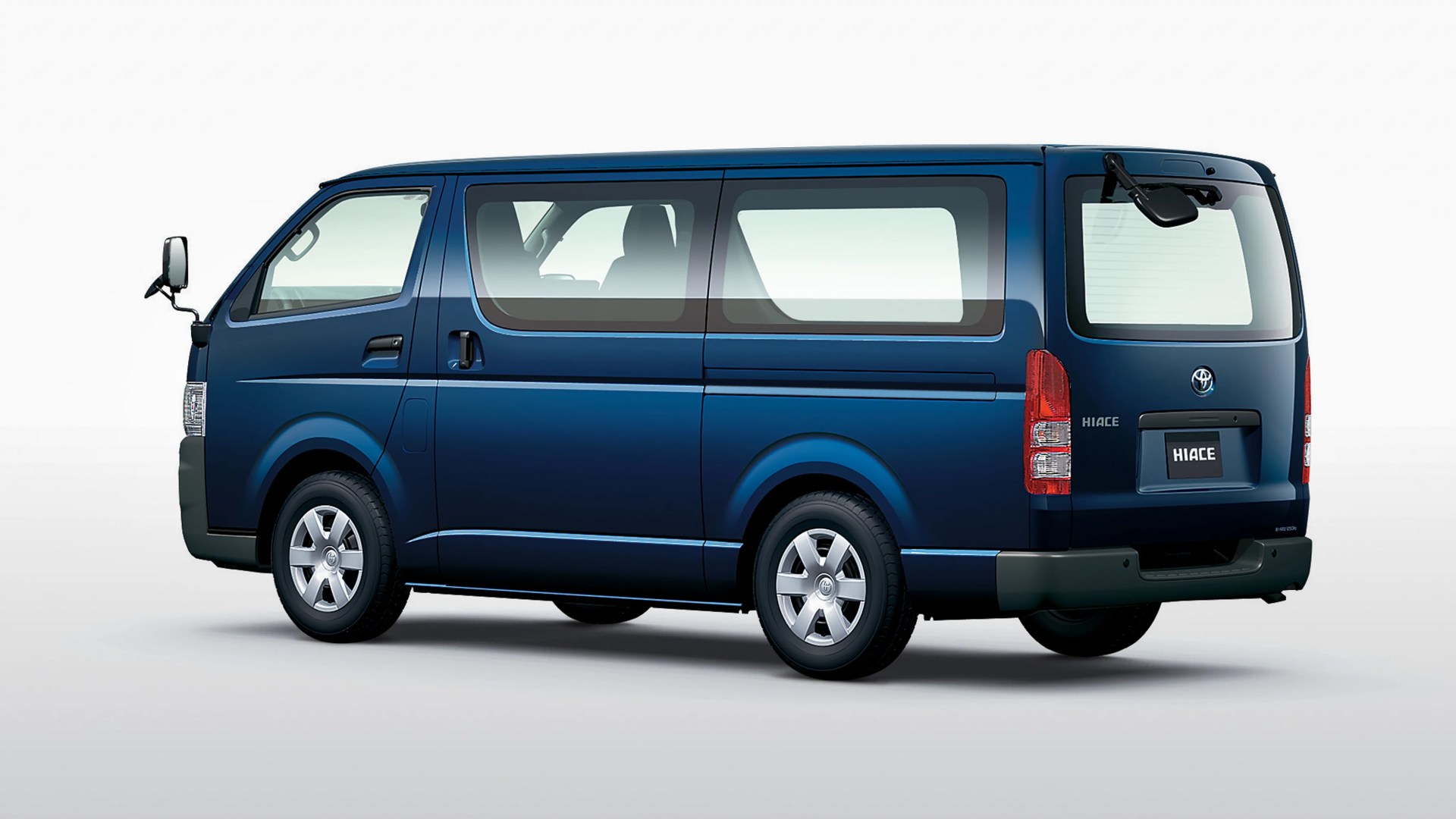 Blue Toyota Hiace van with tinted windows and silver alloy wheels shown from the rear side.