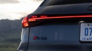 Rear view of a dark gray Audi SQ5 with illuminated taillight and partial license plate visible.