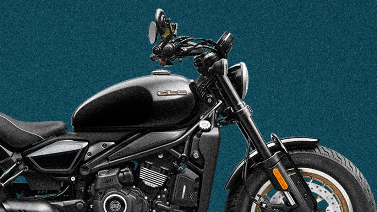Black and silver CLE motorcycle with round headlight and front disc brake against teal background.