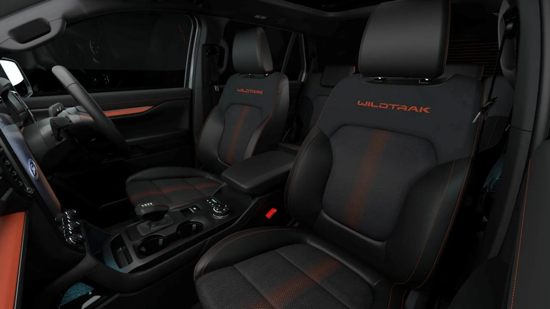 Black and orange leather car seats with "WILDTRAK" embroidery inside a vehicle.