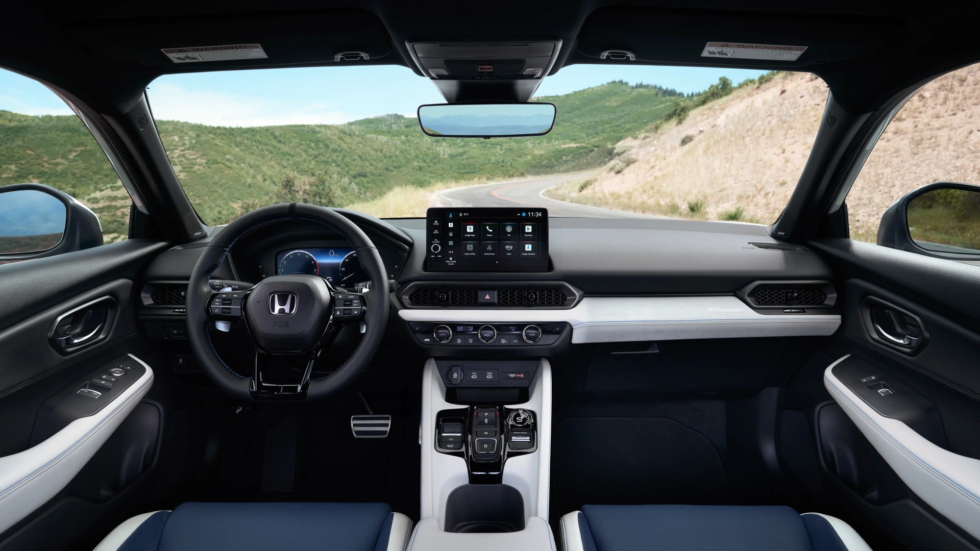 Interior view of a Honda car with a black steering wheel, digital dashboard, touchscreen display, and white and blue seats.