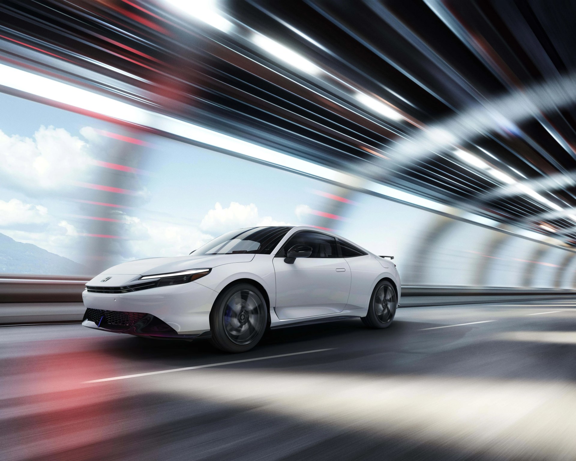 White Honda electric sports car driving on a road with dynamic light streaks above.