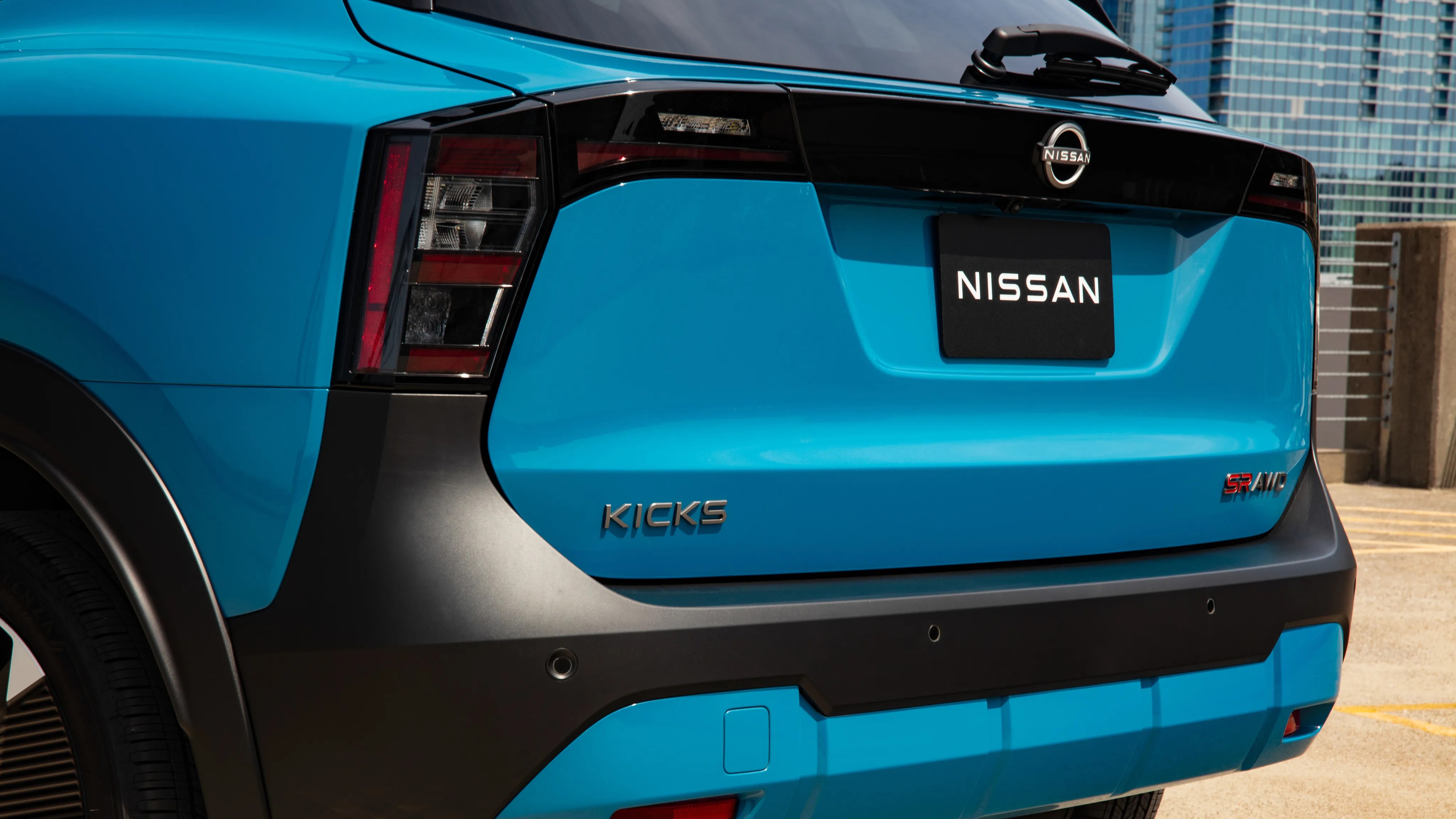Rear view of a blue Nissan Kicks SR AWD with black trim and taillights.