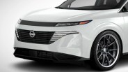Front view of a white Nissan car showing the grille, headlights, and black alloy wheel.