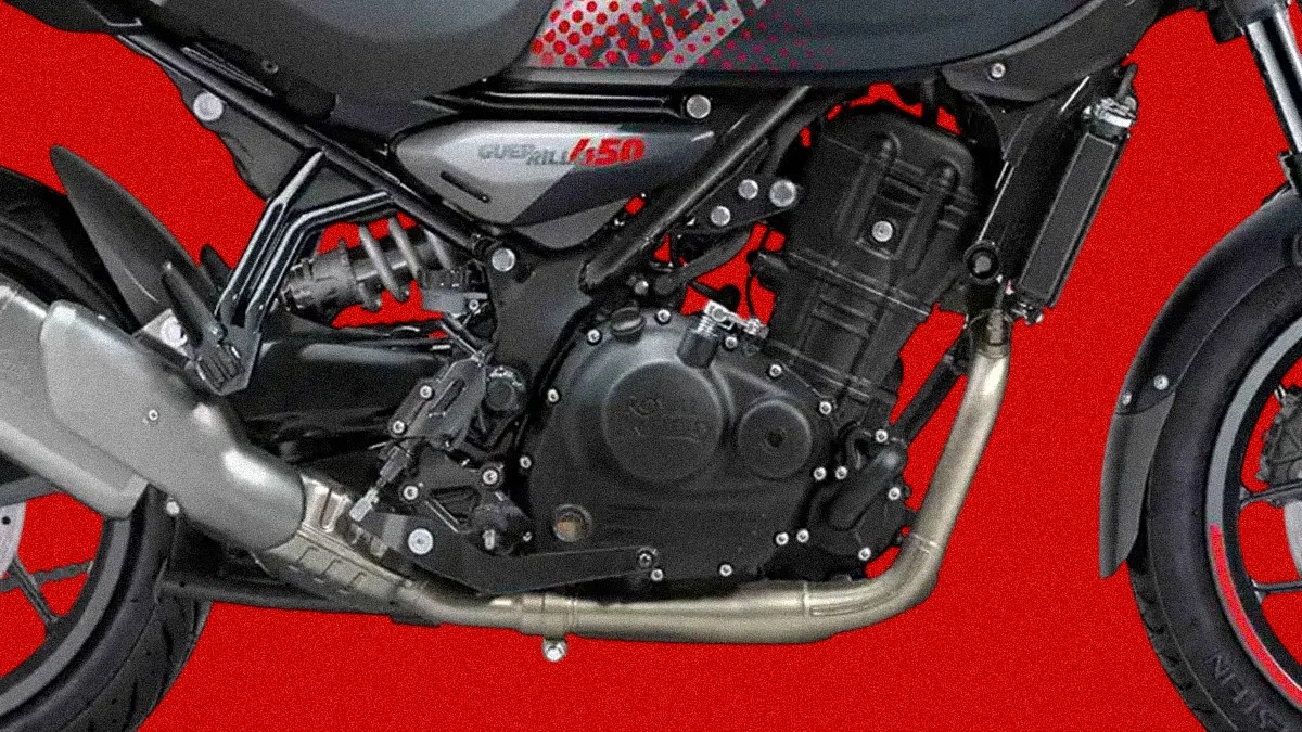Close-up of a black motorcycle engine and exhaust pipe against a red background.