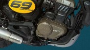 Close-up of a Yezdi motorcycle engine with "69 Scrambler" branding on the yellow side panel and exhaust.