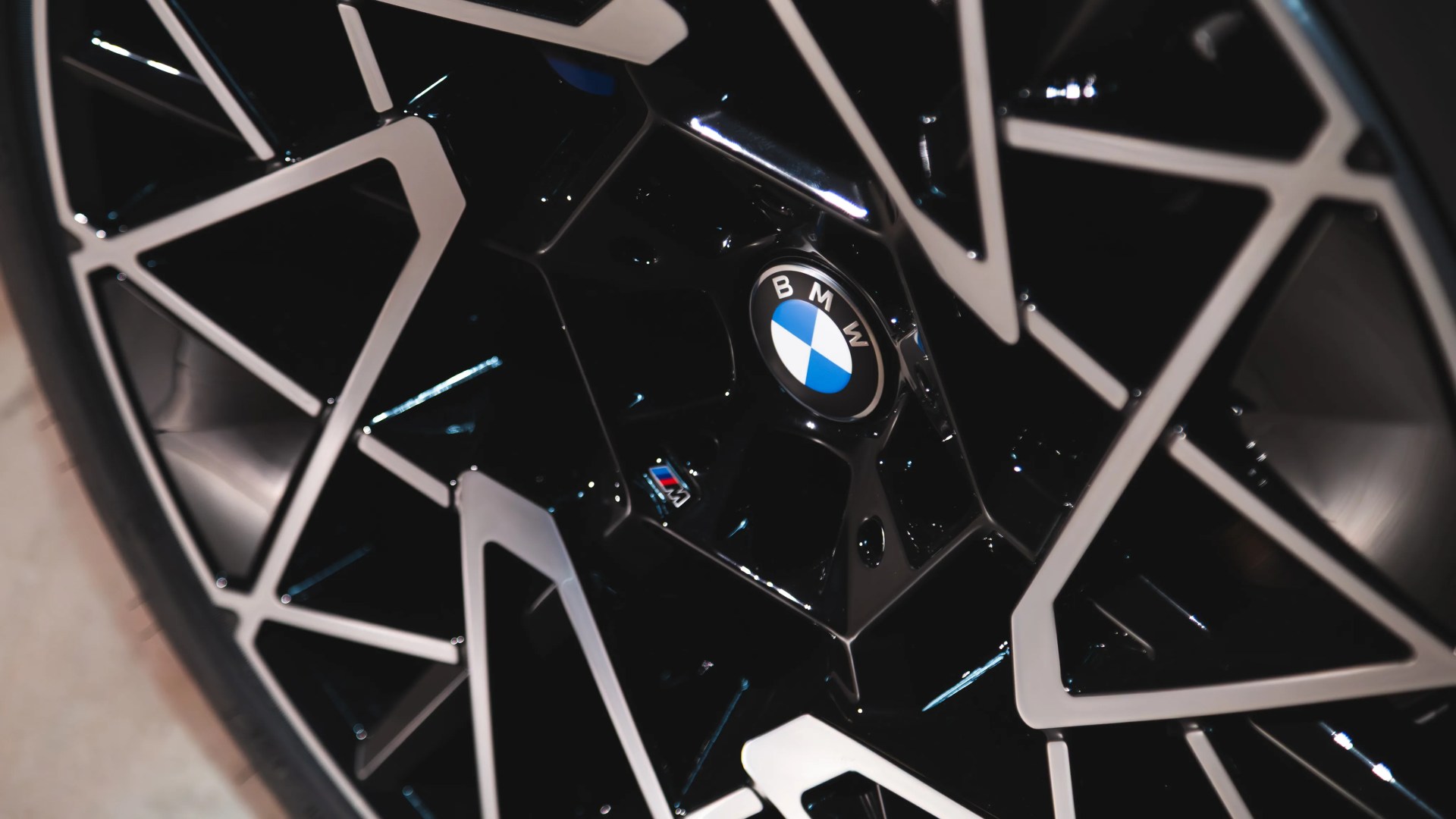 Close-up of a black and silver BMW alloy wheel with the BMW logo and M badge in the center.