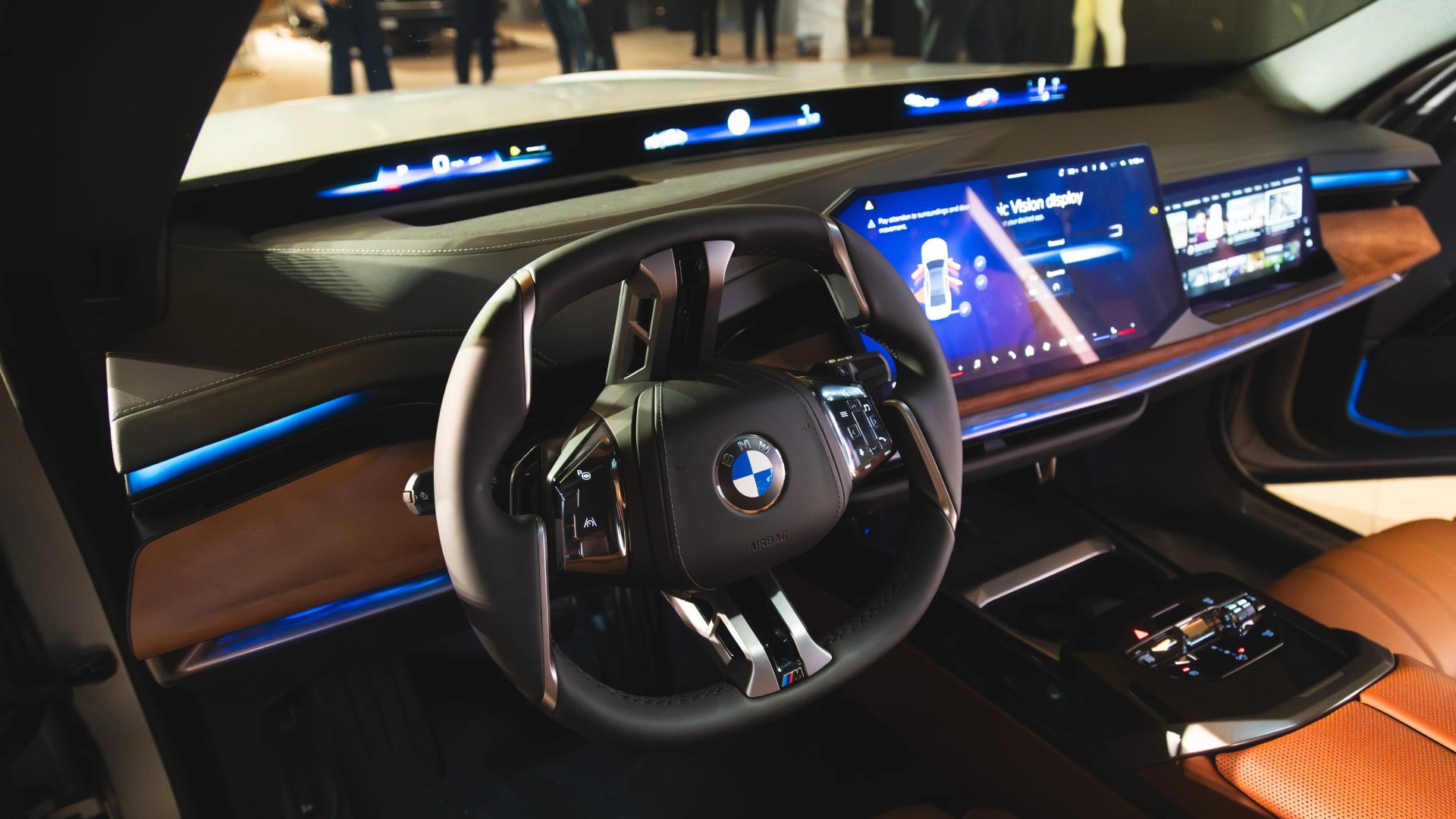 BMW car interior with black and brown leather, digital dashboard, and multifunction steering wheel.