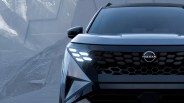 Front view of a dark blue Nissan SUV with illuminated hexagonal LED headlights and a honeycomb grille.