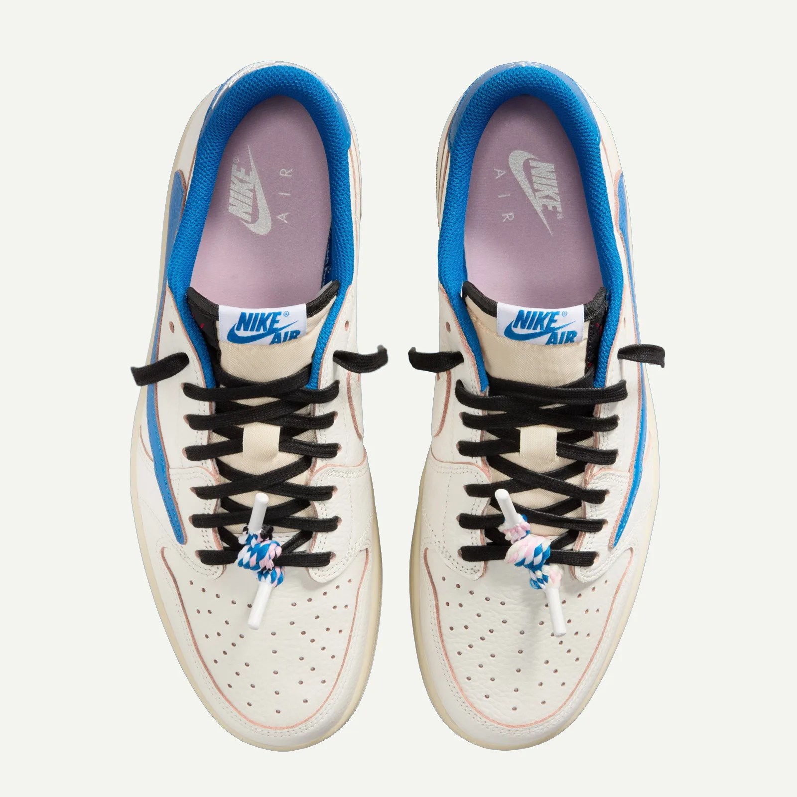 Pair of white Nike Air sneakers with blue inner lining, black laces, and pink and blue lace locks.