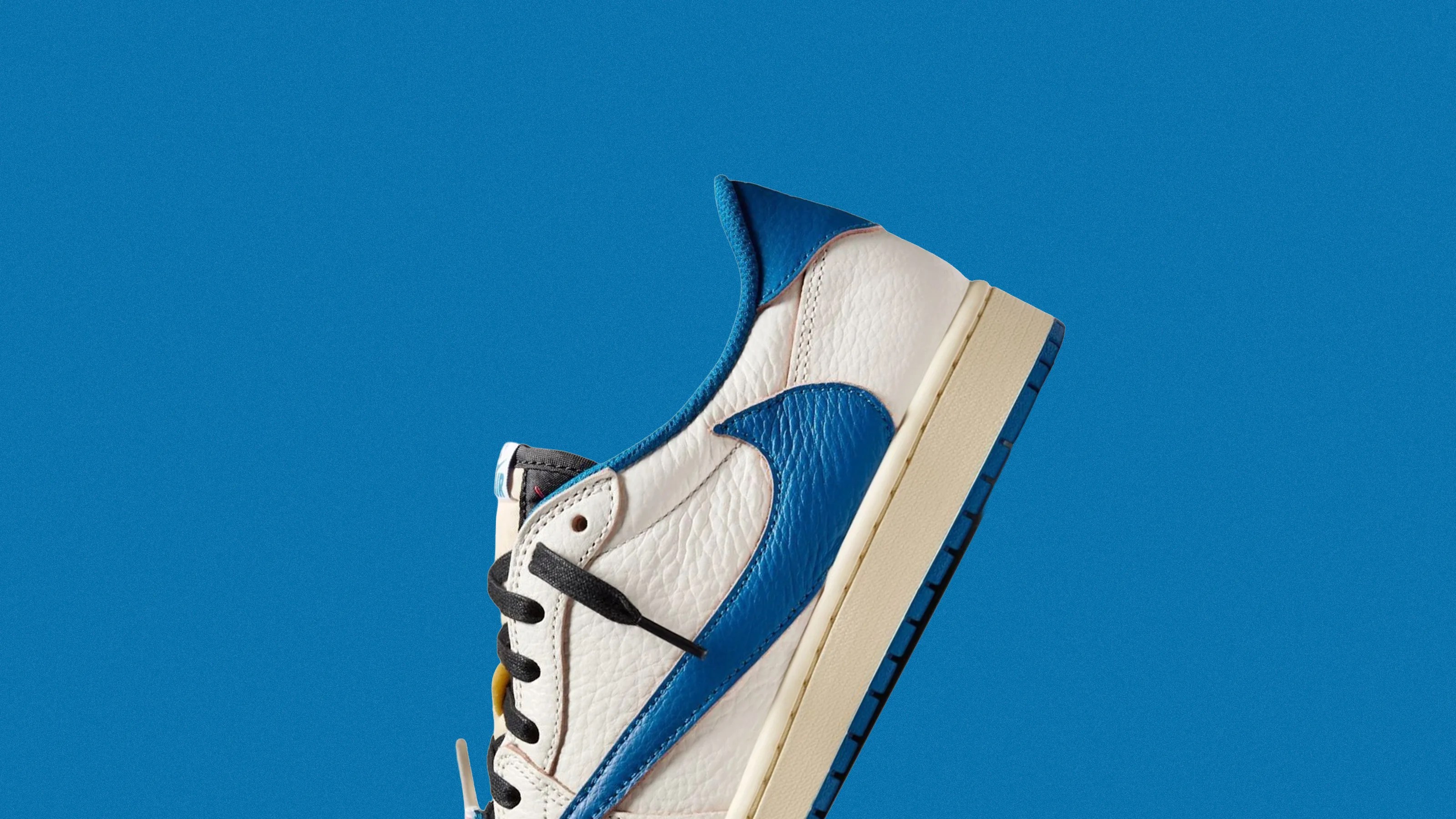 White leather sneaker with blue Nike swoosh and heel tab, black laces, and beige sole against blue background.