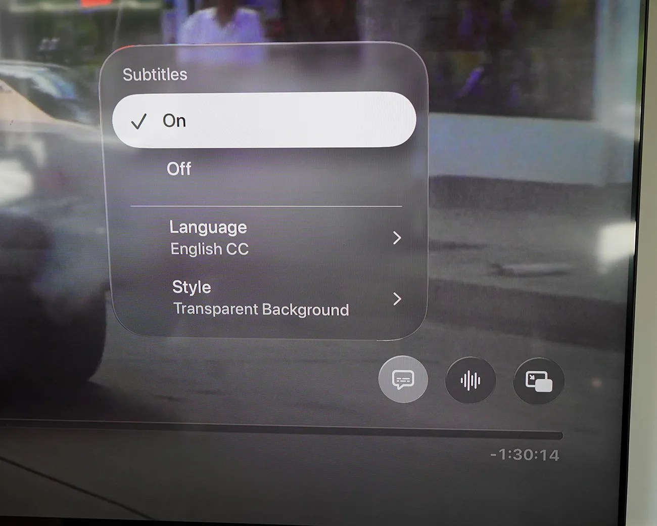 TV screen showing subtitles menu with options On, Off, Language English CC, and Style Transparent Background.
