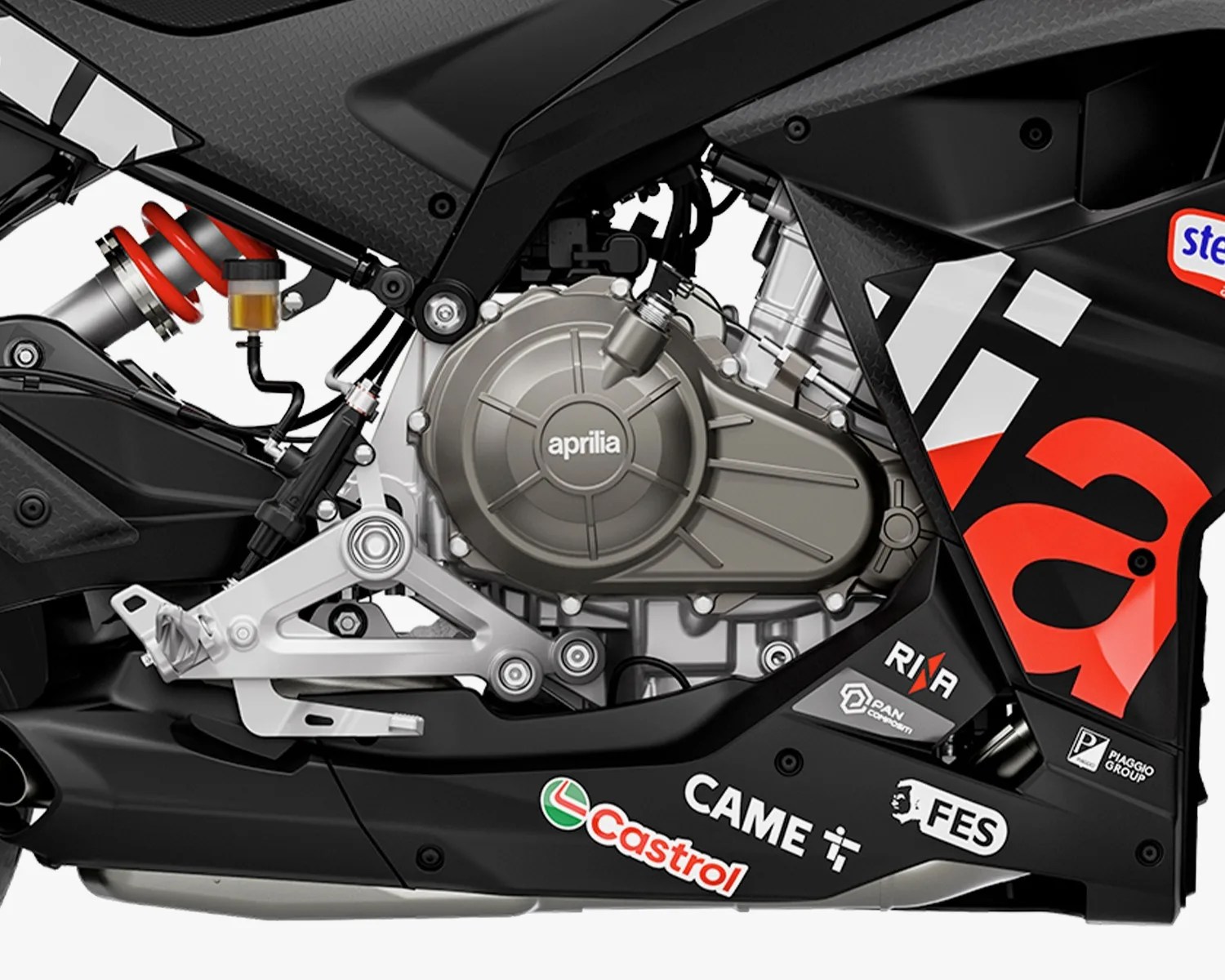Close-up of a black Aprilia motorcycle engine with red suspension spring and sponsor logos including Castrol and Piaggio Group.