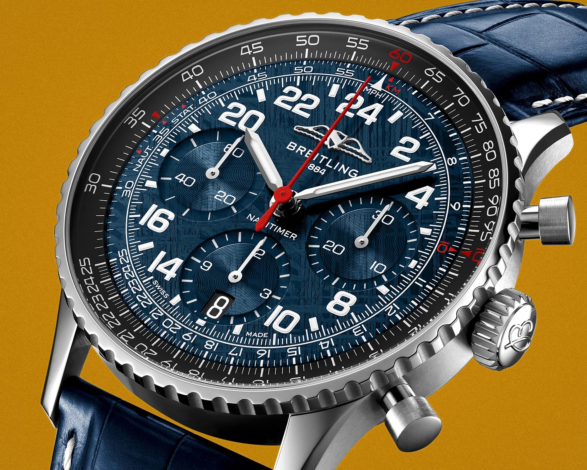 Close-up of a Breitling Navitimer watch with a blue textured dial, white numerals, red second hand, and blue leather strap.