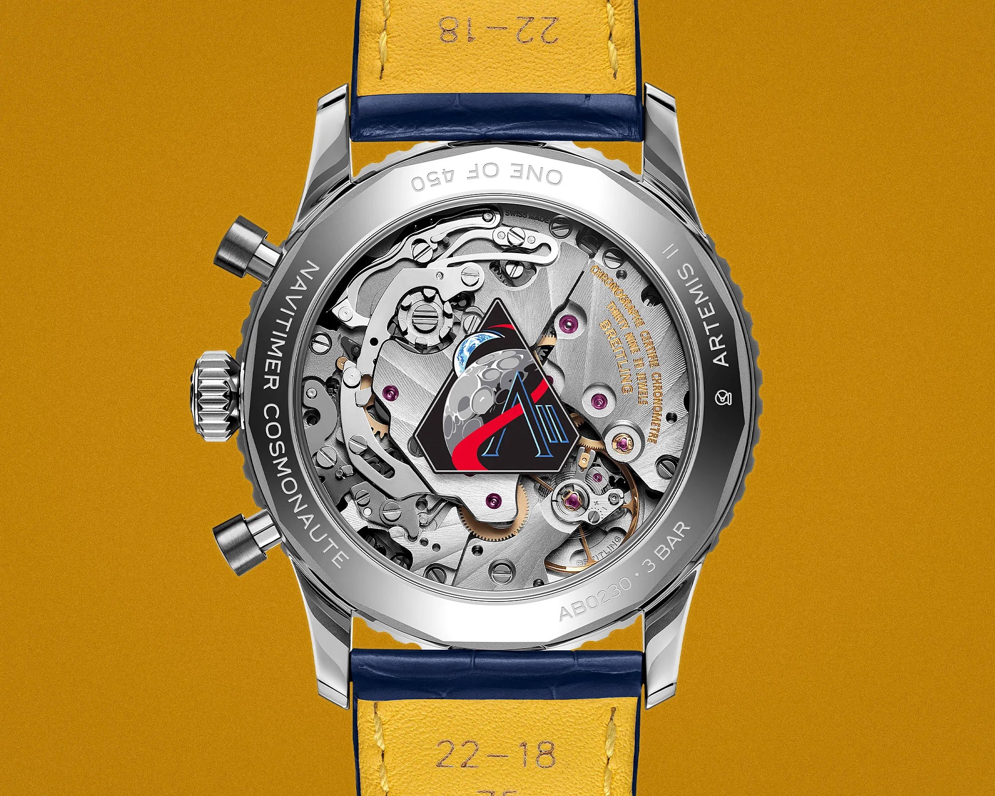 Back view of a Navitimer Cosmonaut stainless steel watch with visible mechanical movement and blue and yellow leather strap.