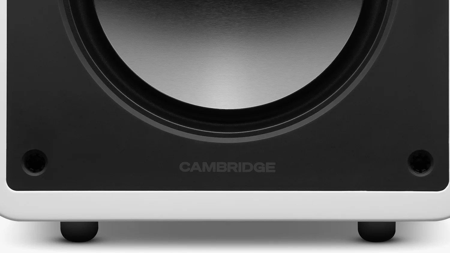 Close-up of a black and white speaker base with the word "CAMBRIDGE" on the front panel.