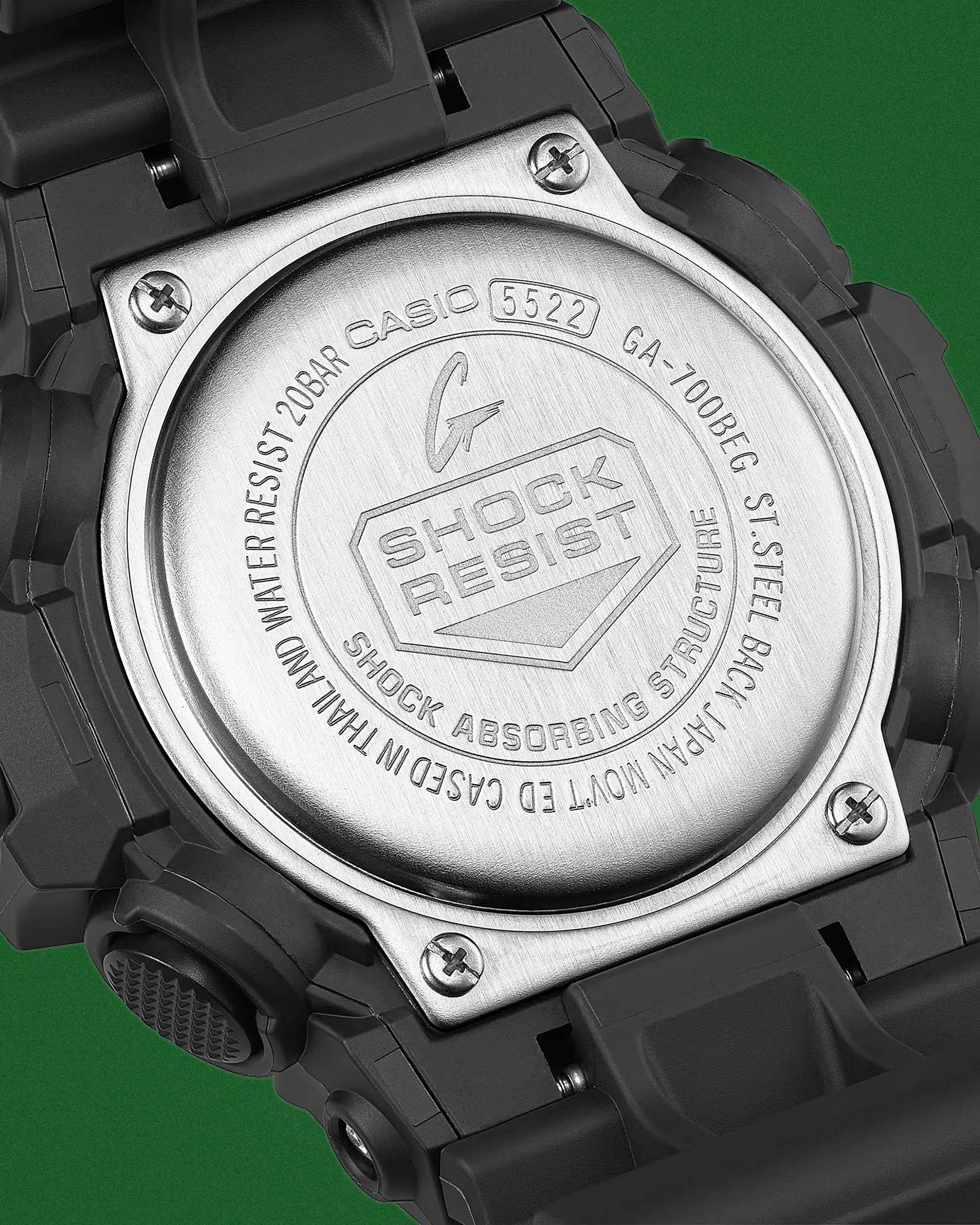 Close-up of the stainless steel back of a black Casio G-Shock watch showing model GA-700BEG and shock resist engraving.