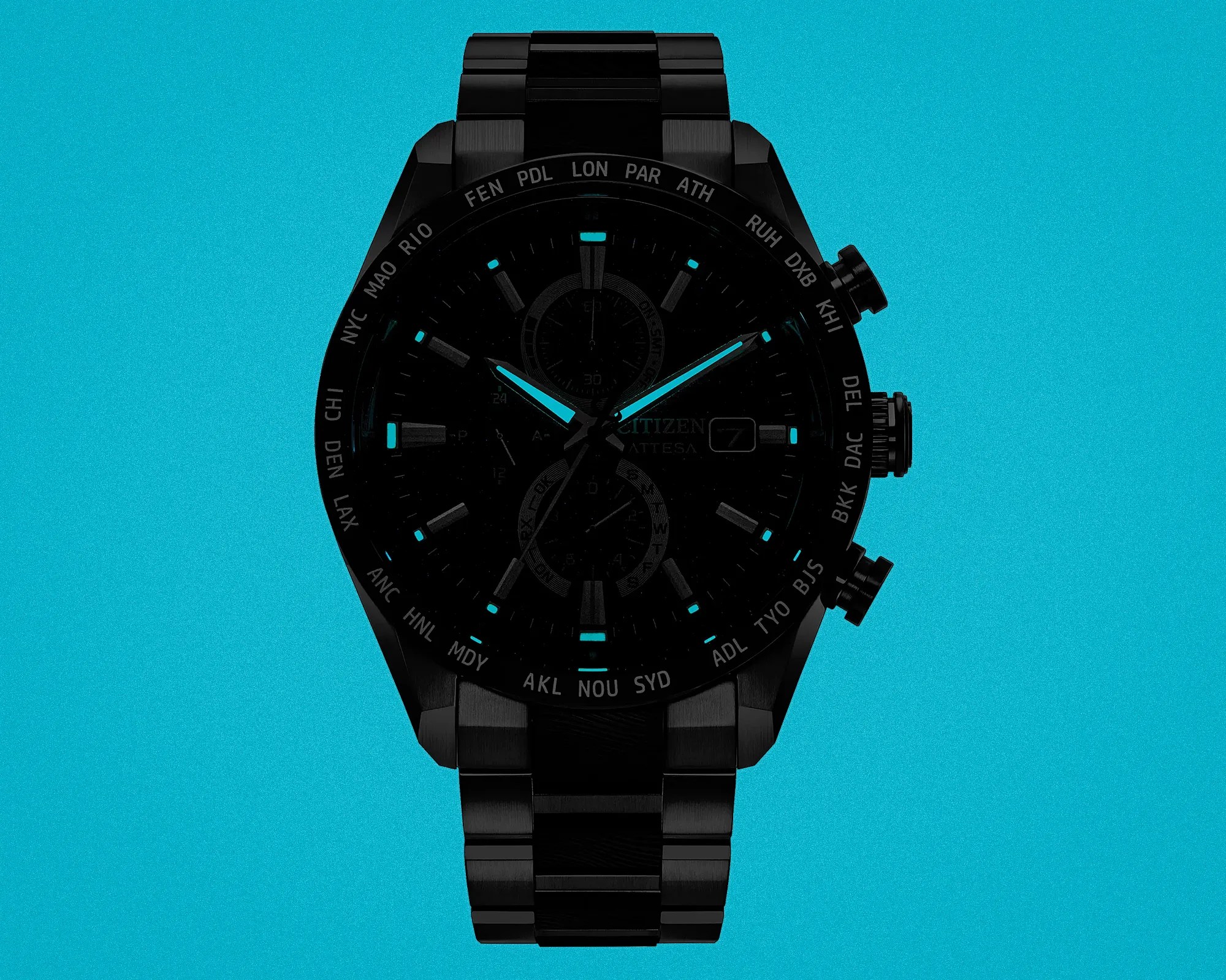 Black metal wristwatch with luminous blue hands and markers on a turquoise background.
