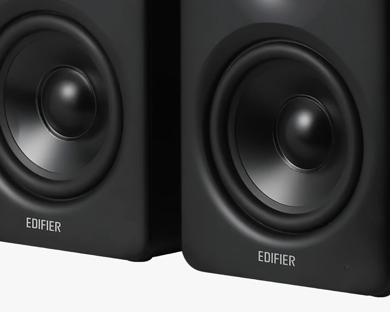 Pair of black Edifier bookshelf speakers with visible woofer cones.