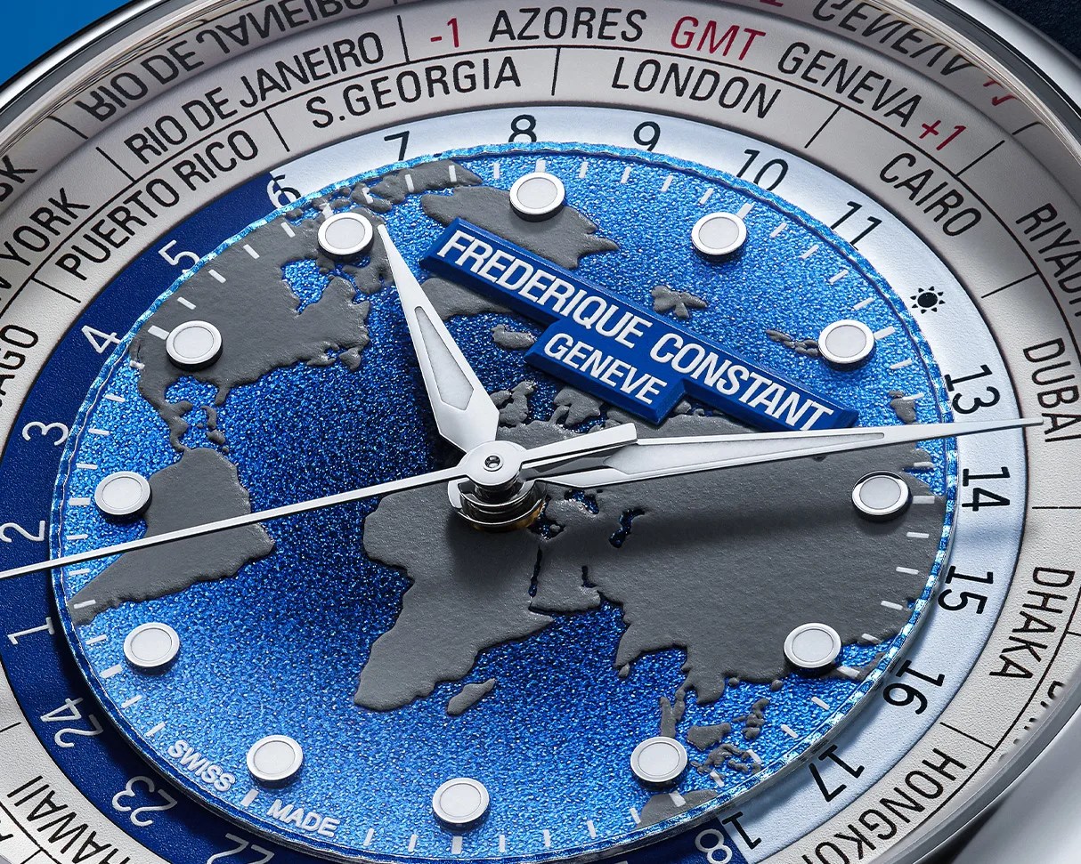 Close-up of a Frederique Constant Gen&egrave;ve watch face with a blue textured world map and silver hour markers and hands.