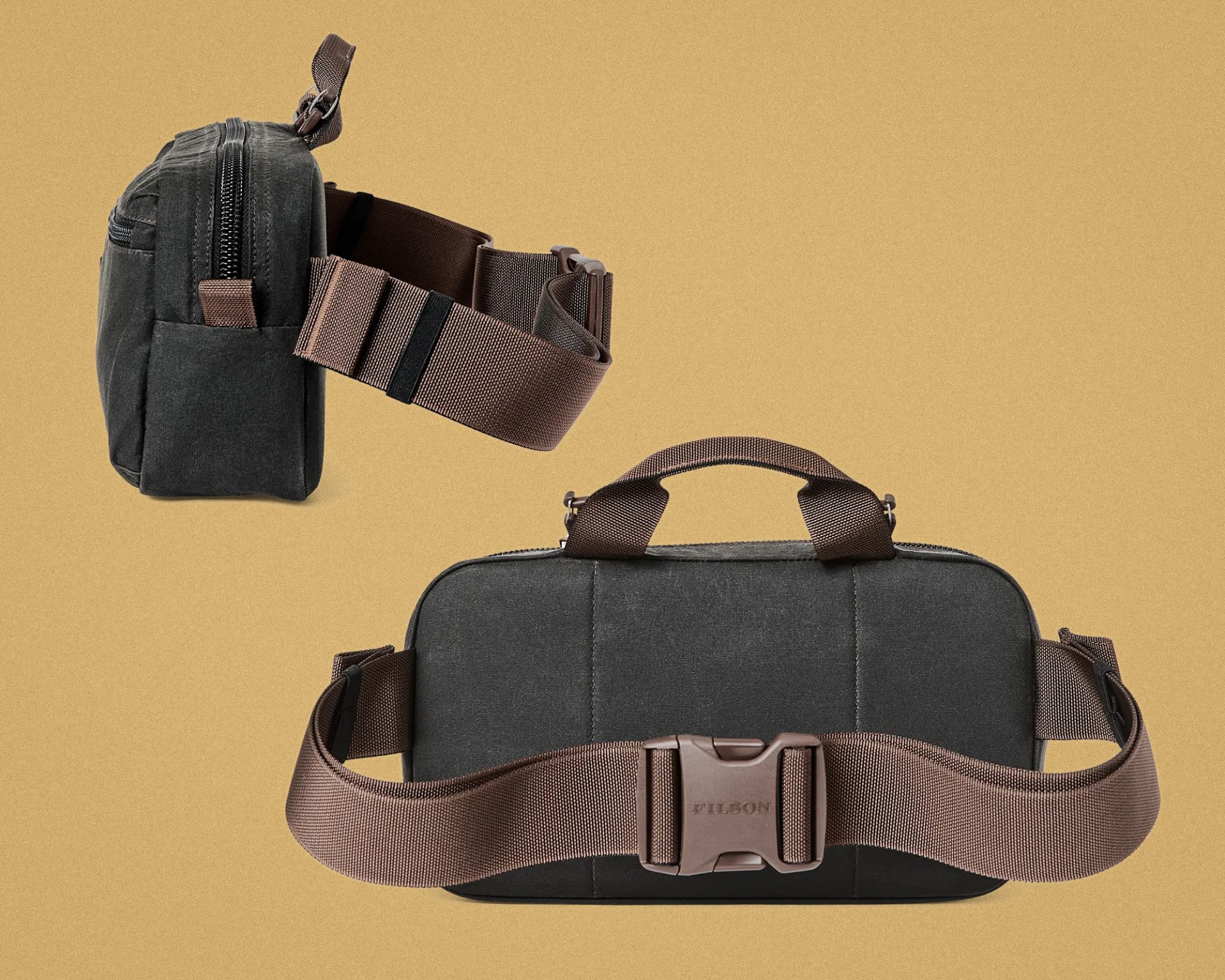 Dark gray rectangular bag with brown adjustable strap and plastic buckle on a tan background.