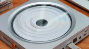 Silver portable CD player with a spinning disc inside and a USB flash drive plugged in.