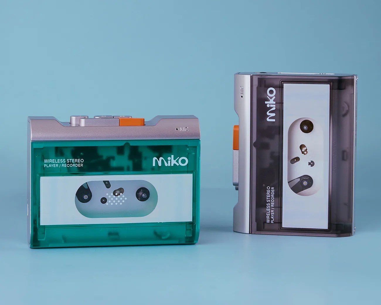 Two wireless stereo cassette player/recorders with transparent green and smoky gray cases labeled "miko" on a blue surface.