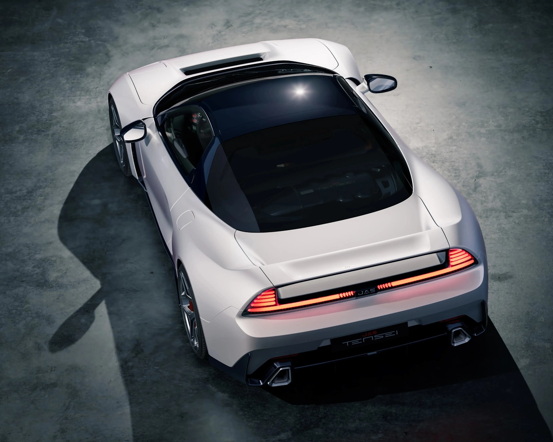 White JAS Tensei sports car with black roof and illuminated rear lights on concrete floor.