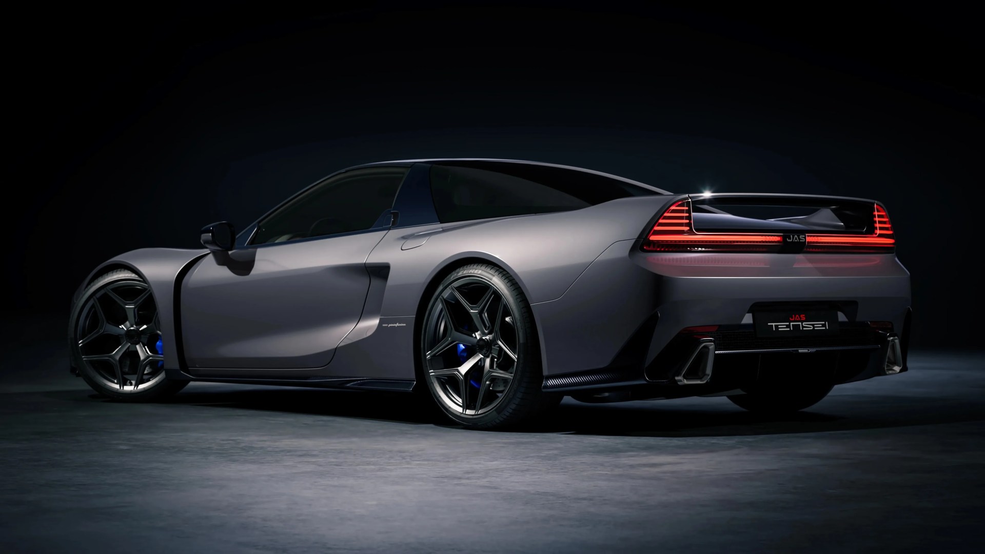 Matte gray sports car with black tinted windows, distinctive rear LED lights, and black alloy wheels on a dark floor.