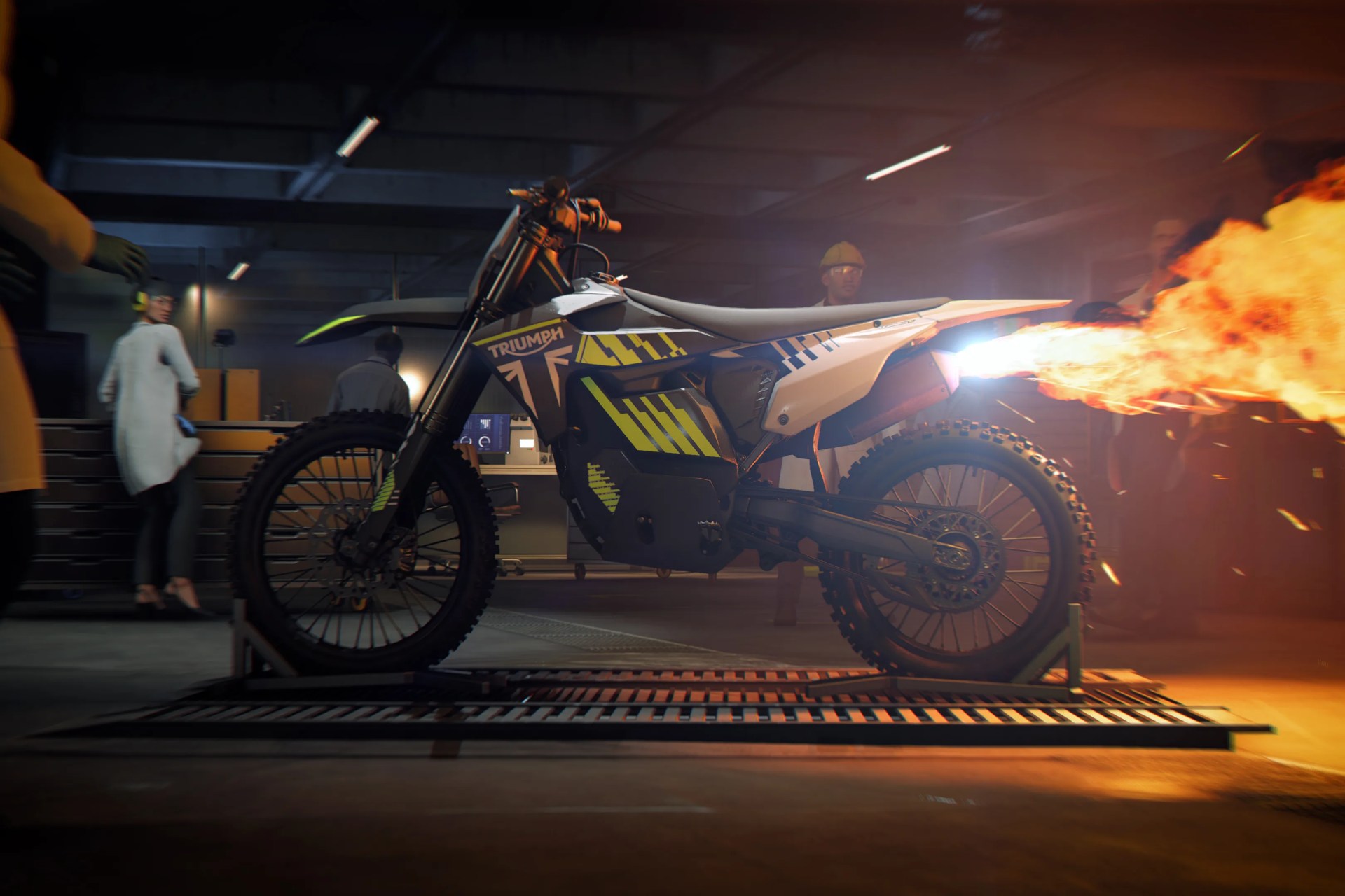 Off-road Triumph motorcycle with yellow and black graphics emitting flames from the exhaust in a garage.