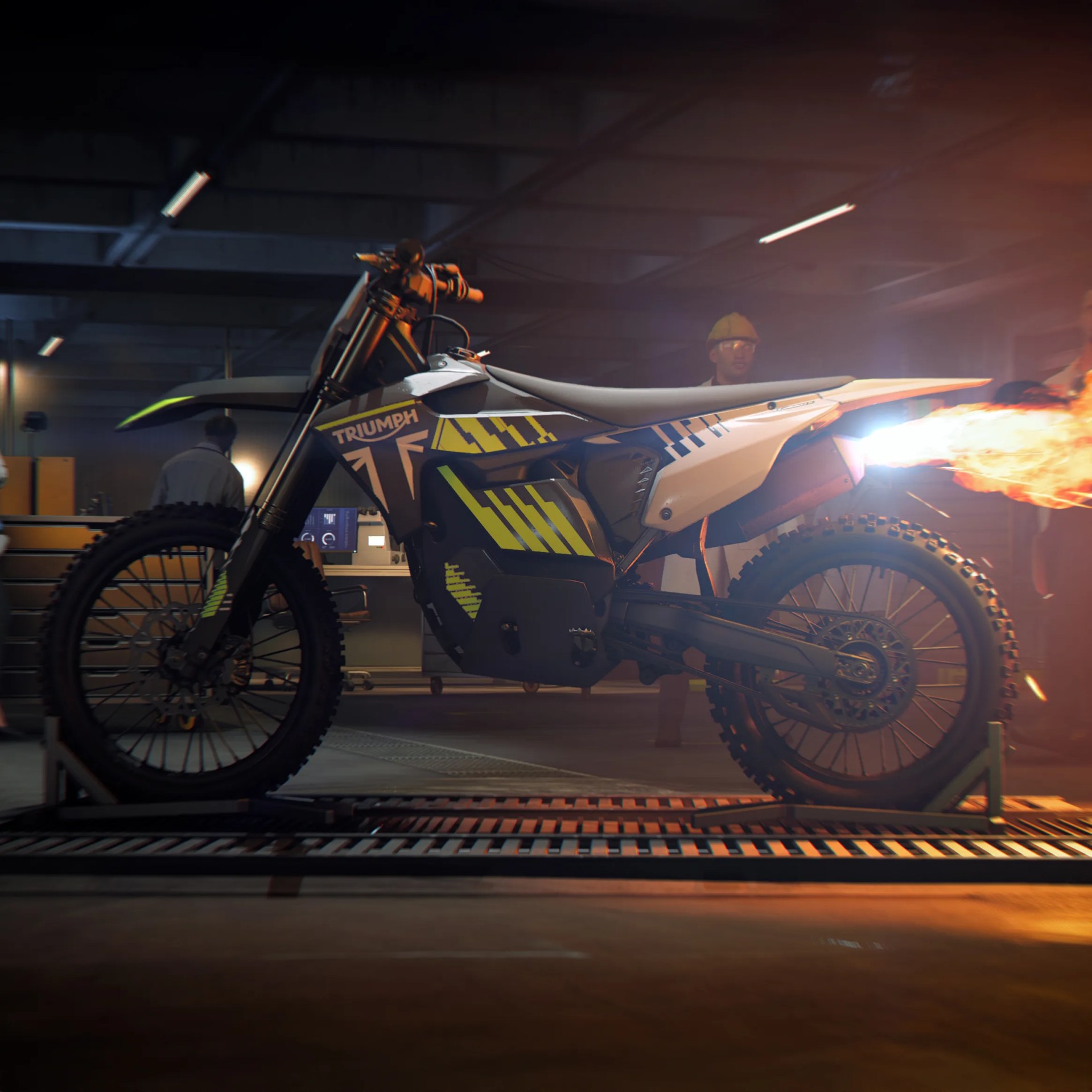 Electric dirt bike with Triumph branding and yellow graphic accents emitting flames from the exhaust in a garage setting.